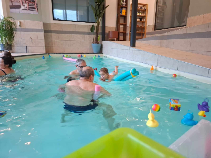 Le moniteur est dans l'eau lors d'une séance bébés nageurs